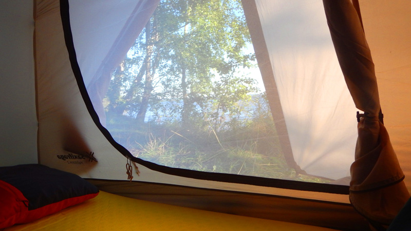 Светёлка
каякера утренней порой с правильным видом из окна.  
Два входа – это очень удобно. Солнце уже припекает, но в палатке приятный
сквознячок.&nbsp;