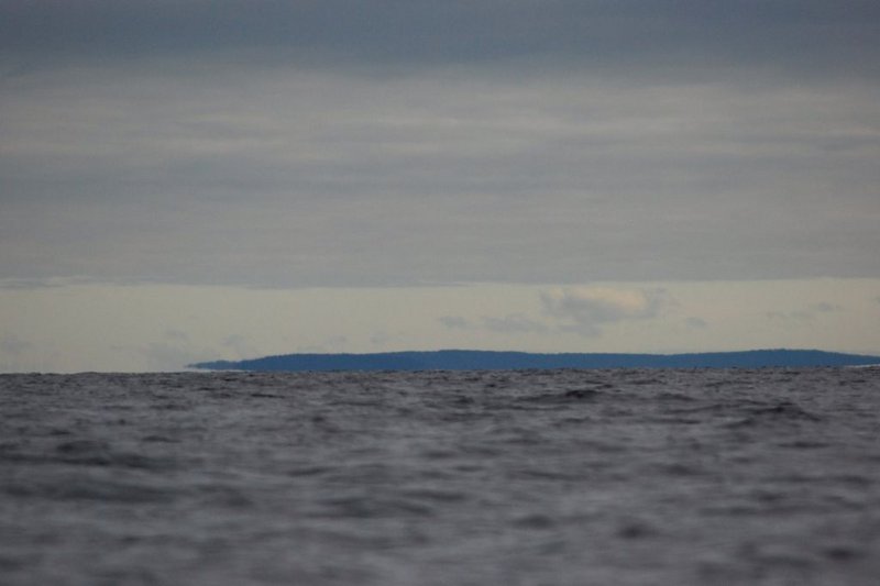 Облака
постепенно стали разряжаться, море стало голубым.9:56.
Достиг Пежострова. Пройдено ровно 10 км!!! Ещё день не начался, а уже треть
нормы сделал!!!

Передо
мной очередной пролив, называется Прямая Салма. Впереди на горизонте видны
тёмно серые полоски островов. Беру курс на самый крайний из них. Это либо
Кишкин, либо Черемшиха, либо Сидоров. Там на месте разберусь. Мне на Сидоров,
на самый дальний.&nbsp;