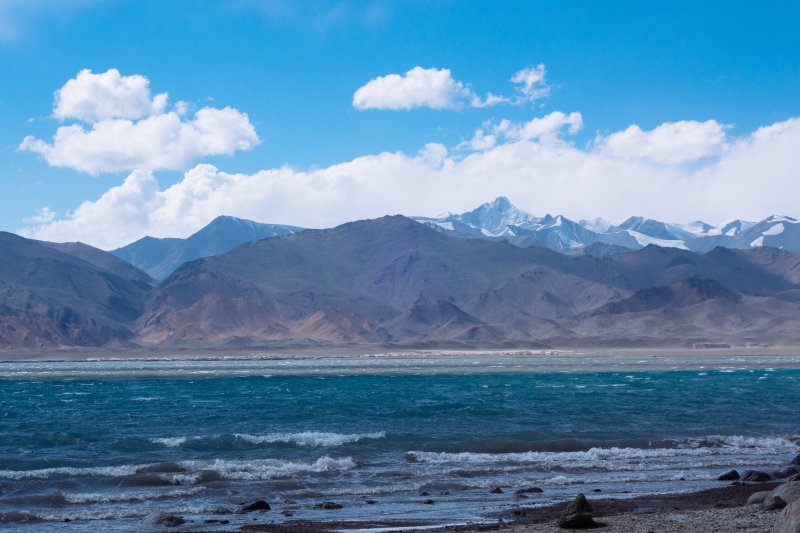 Грунт, образующий мыс, был мягкий,
нога проваливалась по щиколотку. То ли выносы реки, то ли оттаявшая мерзлота.
Поскольку погода стала получше, ветер
гораздо тише, то счел возможным продолжить путь. Хотелось пересечь следующий
залив, километра через три будет мыс, состоящий из холмов с крутыми склонами. Предположил,
что там можно будет укрыться от ветра. Переоделся в подсохшую на ветру ходовую
одежду и в 15:56 вышел на воду. Но как это и бывает, только отошел от берега
метров на пятьсот - ветер начал усиливаться. Только в этот раз он был попутный,
поэтому я аккуратно серфил на волнах в направлении следующего мыса. Постепенно,
с удалением от берега, волна становилась все больше. Через какой-то период шла
серия из двух-трех волн, особенно высоких. Удерживать байдарку от поворота удавалось
с трудом, было очень неприятно. Возникала опасность брочинга. До расположенного
по направлению ветра берега острова Северный минимум пара километров. Вода
с температурой
8 - 10°С делала печальной перспективу плавания на спасжилете без сухого костюма.
Поэтому старался действовать максимально осторожно, веслом пользовался больше
для поддержания курса и баланса, чем для продвижения вперед. Ветер и так тащил
меня с хорошей скоростью.
При подходе к мысу увидел между ним и
ближайшим островом буруны – явно мель, но сманеврировать и обойти остров уже не
получалось, решил проскочить. Почувствовал, как байдарка вроде за что-то задела,
но не остановилась. Зайдя за мыс, действительно
оказался в зоне ветровой тени, в небольшом заливе, где получилось спокойно остановиться
на воде и передохнуть. Попив воды и съев конфетку, решил попробовать пройти дальше,
к восточному берегу. Когда байдарку начало покачивать волнами, появилось
ощущение, что ступни в байдарке омывает водой. Но в тот момент не придал этому никакого
значения, решив, что это затекла вода от гребней волн, неоднократно накрывавших
меня выше верхнего края юбки.
За мысом оказался сильный встречный
ветер. Странно, он дул здесь с направления – N, хотя с другой, западной стороны
мыса был – NW.
Поборовшись с ним пару минут неожиданно ощутил, что вода в байдарке уже омывает
сиденье, а ведь оно сантиметрах в десяти выше дна. Еще обратил внимание на погруженные
борта байдарки, осадка стала заметно ниже, чем обычно. Похоже начал тонуть! Осторожно
выполнил правый разворот и пошел обратно за мыс в залив, нужно было срочно
выбираться на берег, пока окончательно не потонул. Радуясь, что живой, вылез в
16:30. Сильно потяжелевшую байдарку вытащил совсем немного, параллельно
береговой линии, боялся погнуть каркас. Быстро переодевшись в сухое, полез вытаскивать
наружу гермы и вычерпывать воду.
По цепочки пузырьков с баллона
правого борта обнаружилось место, где он травил. В этом был плюс ситуации, с заполненной
водой байдаркой. Постепенно с помощью котелка вычерпал основное количество воды
и затащил полегчавшую байдарку чуть выше на берег.
Открыл все гермы и убедился в
верности утверждений, что только завернутая на пять полуоборотов горловина
пвх-гермы помогает от попадания внутрь влаги. Меньшее число полуоборотов
что-нибудь да пропускает. В моем случае, влажной внутри оказалась герма с палаткой.
Но поскольку внутри была еще одна герма, собственно штатная упаковка, швы
которой я заранее загерметизировал клеем, то обошлось без тяжелых последствий.
Губкой собрал из байдарки остатки
воды и разглядел причину ее появления. На сером днище с внутренней стороны выделялось
светло-желтое пятно – это просвечивал освещенный солнцем берег. Дырка была
небольшая, размером с ноготь указательного пальца, почти округлая, со следами
задира в сторону кормы. Расположена под трубкой центральной распорки, т.е.
пробитие было явно при прохождении мели. На такую маленькую пробоину жалко тратить
время на приклеивание заплатки, тем более что качественно склеивать лучше дома,
в сухости и тепле. Оставил пока все подсыхать, утром ликвидирую течь с помощью армированного
сантехнического скотча.
Тем временем по небу опять поползли тучи,
со стороны хребта Каракуль. Ветер продолжал усиливаться, и теперь даже в этот
залив, хоть и прикрытый холмами, стали прорываться его порывы. Прорывались они
ударом, одним из которых байдарку дважды перевернуло, после чего я догрузил ее камнями.
Потом порывами ветра начало таскать по берегу весло – засунул его под груду
камней. Вообще погода не переставала удивлять сегодня. Из-за края мыса было
видно несущиеся по ветру волны, пены становилось все больше. Я решил залезть на
перемычку между холмами, хотелось осмотреть местность с северной стороны озера.
Наверху ветер оказался ровный, сила его была такой, что можно было наклониться
и лежать на нем. Сверху перемычки стало видно какие-то странные явления в долине
дельты реки Караджилга и восточнее - в разных местах возникали облака пыли,
размером где-то три-четыре сотни метров. Несколько минут такое облако двигалось
гонимое ветром, постепенно рассеиваясь. Вскоре увидел подобное же, но на поверхности
озера, юго-западнее меня, только тут облако было белое, как туман, и в нем
играла множественная радуга. Спустившись вниз, довелось увидеть это явление
поближе. С юго-восточной стороны от полуострова, где я находился, на покрытой
гребнями волн поверхности рисунок изменился. Появилось округлое пятно, метров
под триста-четыреста в диаметре, гребни волн стали расходится от него
радиально, над ними поднялось белое облако. Скоро это облако с очень сильным
порывом ветра достигло меня, лицо обдало влагой. Облако состояло из водяной
пыли поднятой ветром с поверхности воды. Пыль была настолько мелкой, что
оседала несколько минут. Сначала не понял откуда на лице влага, ведь дождей то
в этой местности не бывает. Потом догадался, почувствовав ее горько-соленый
вкус. Порыв ветра был такой силы, что даже возникло опасение, как бы не сдуло спрятанные
в куче камней на склоне гермы с вещами. Вернувшись домой прочитал про похожее явление
в википедии – микрошквал (англ. microburst). Независимо от того, оно ли это,
оказаться в этот момент рядом на воде крайне не хотелось бы. Подумалось, что
вовремя я дно байдарки пробил.
Понаблюдав за необычными для меня чудесами
погоды, вспомнил про ужин. Выбрал наиболее укрытое место в куче камней, на середине
подъема на холм, и не без труда занялся готовкой. Порывы ветра били отовсюду,
со всех направлений, кроме как со стороны склона. Пришлось придерживать
кастрюльку до самого конца готовки одной рукой, иначе бы перевернуло всю
конструкцию в первую же минуту.
Пока готовил и ел, солнце село, и я начал
подмерзать. Разогрелся таская камни и строя стенку, с трех сторон от
выровненной под палатку площадки. Об установки палатки в штатном варианте и
речи не могло быть – она явно не была рассчитана на порывы ветра такой силы, да
еще и с произвольных направлений. Решил действовать проверенным пару дней назад
способом, растянуть только внутреннюю палатку, не устанавливая дуг. Облака
водяной пыли больше не приносило, тент тут мне особо не нужен. По периметру
внутренней палатки выложил из камней стенку, чуть выше колена высотой.
Внутреннюю палатку растянул веревками за угловые оттяжки и закрепил за камни.
Внутрь засунул каремат, надувной коврик, оба спальника. Залез сам, поразившись
обилию песка внутри. Ветер натащил его туда через сетку в верхней частию
палатки. Но песок – это не вода, спать можно. Натянул бафф на лицо, для защиты
от пыли, и спокойно уснул.
День 6 (19.08.2025) 22 км.
Проснулся в 5:30, по будильнику.
Начинался рассвет, поэтому схватив фотоаппарат пошагал на вершину холма.
Сегодня все окружающие озеро вершины было хорошо видно, над Заалайским хребтом
вообще ни облачка. И что больше всего порадовало – штиль. Осмотревшись, отметил
приличное расхождение с картой, по факту полуостров, где я находился, почти
стал островом, с берегом его соединяла только узкая полоска суши с северо-западного
края. Грунт, образующий мыс, был мягкий,
нога проваливалась по щиколотку. То ли выносы реки, то ли оттаявшая мерзлота.
Поскольку погода стала получше, ветер
гораздо тише, то счел возможным продолжить путь. Хотелось пересечь следующий
залив, километра через три будет мыс, состоящий из холмов с крутыми склонами. Предположил,
что там можно будет укрыться от ветра. Переоделся в подсохшую на ветру ходовую
одежду и в 15:56 вышел на воду. Но как это и бывает, только отошел от берега
метров на пятьсот - ветер начал усиливаться. Только в этот раз он был попутный,
поэтому я аккуратно серфил на волнах в направлении следующего мыса. Постепенно,
с удалением от берега, волна становилась все больше. Через какой-то период шла
серия из двух-трех волн, особенно высоких. Удерживать байдарку от поворота удавалось
с трудом, было очень неприятно. Возникала опасность брочинга. До расположенного
по направлению ветра берега острова Северный минимум пара километров. Вода
с температурой
8 - 10°С делала печальной перспективу плавания на спасжилете без сухого костюма.
Поэтому старался действовать максимально осторожно, веслом пользовался больше
для поддержания курса и баланса, чем для продвижения вперед. Ветер и так тащил
меня с хорошей скоростью.
При подходе к мысу увидел между ним и
ближайшим островом буруны – явно мель, но сманеврировать и обойти остров уже не
получалось, решил проскочить. Почувствовал, как байдарка вроде за что-то задела,
но не остановилась. Зайдя за мыс, действительно
оказался в зоне ветровой тени, в небольшом заливе, где получилось спокойно остановиться
на воде и передохнуть. Попив воды и съев конфетку, решил попробовать пройти дальше,
к восточному берегу. Когда байдарку начало покачивать волнами, появилось
ощущение, что ступни в байдарке омывает водой. Но в тот момент не придал этому никакого
значения, решив, что это затекла вода от гребней волн, неоднократно накрывавших
меня выше верхнего края юбки.
За мысом оказался сильный встречный
ветер. Странно, он дул здесь с направления – N, хотя с другой, западной стороны
мыса был – NW.
Поборовшись с ним пару минут неожиданно ощутил, что вода в байдарке уже омывает
сиденье, а ведь оно сантиметрах в десяти выше дна. Еще обратил внимание на погруженные
борта байдарки, осадка стала заметно ниже, чем обычно. Похоже начал тонуть! Осторожно
выполнил правый разворот и пошел обратно за мыс в залив, нужно было срочно
выбираться на берег, пока окончательно не потонул. Радуясь, что живой, вылез в
16:30. Сильно потяжелевшую байдарку вытащил совсем немного, параллельно
береговой линии, боялся погнуть каркас. Быстро переодевшись в сухое, полез вытаскивать
наружу гермы и вычерпывать воду.
По цепочки пузырьков с баллона
правого борта обнаружилось место, где он травил. В этом был плюс ситуации, с заполненной
водой байдаркой. Постепенно с помощью котелка вычерпал основное количество воды
и затащил полегчавшую байдарку чуть выше на берег.
Открыл все гермы и убедился в
верности утверждений, что только завернутая на пять полуоборотов горловина
пвх-гермы помогает от попадания внутрь влаги. Меньшее число полуоборотов
что-нибудь да пропускает. В моем случае, влажной внутри оказалась герма с палаткой.
Но поскольку внутри была еще одна герма, собственно штатная упаковка, швы
которой я заранее загерметизировал клеем, то обошлось без тяжелых последствий.
Губкой собрал из байдарки остатки
воды и разглядел причину ее появления. На сером днище с внутренней стороны выделялось
светло-желтое пятно – это просвечивал освещенный солнцем берег. Дырка была
небольшая, размером с ноготь указательного пальца, почти округлая, со следами
задира в сторону кормы. Расположена под трубкой центральной распорки, т.е.
пробитие было явно при прохождении мели. На такую маленькую пробоину жалко тратить
время на приклеивание заплатки, тем более что качественно склеивать лучше дома,
в сухости и тепле. Оставил пока все подсыхать, утром ликвидирую течь с помощью армированного
сантехнического скотча.
Тем временем по небу опять поползли тучи,
со стороны хребта Каракуль. Ветер продолжал усиливаться, и теперь даже в этот
залив, хоть и прикрытый холмами, стали прорываться его порывы. Прорывались они
ударом, одним из которых байдарку дважды перевернуло, после чего я догрузил ее камнями.
Потом порывами ветра начало таскать по берегу весло – засунул его под груду
камней. Вообще погода не переставала удивлять сегодня. Из-за края мыса было
видно несущиеся по ветру волны, пены становилось все больше. Я решил залезть на
перемычку между холмами, хотелось осмотреть местность с северной стороны озера.
Наверху ветер оказался ровный, сила его была такой, что можно было наклониться
и лежать на нем. Сверху перемычки стало видно какие-то странные явления в долине
дельты реки Караджилга и восточнее - в разных местах возникали облака пыли,
размером где-то три-четыре сотни метров. Несколько минут такое облако двигалось
гонимое ветром, постепенно рассеиваясь. Вскоре увидел подобное же, но на поверхности
озера, юго-западнее меня, только тут облако было белое, как туман, и в нем
играла множественная радуга. Спустившись вниз, довелось увидеть это явление
поближе. С юго-восточной стороны от полуострова, где я находился, на покрытой
гребнями волн поверхности рисунок изменился. Появилось округлое пятно, метров
под триста-четыреста в диаметре, гребни волн стали расходится от него
радиально, над ними поднялось белое облако. Скоро это облако с очень сильным
порывом ветра достигло меня, лицо обдало влагой. Облако состояло из водяной
пыли поднятой ветром с поверхности воды. Пыль была настолько мелкой, что
оседала несколько минут. Сначала не понял откуда на лице влага, ведь дождей то
в этой местности не бывает. Потом догадался, почувствовав ее горько-соленый
вкус. Порыв ветра был такой силы, что даже возникло опасение, как бы не сдуло спрятанные
в куче камней на склоне гермы с вещами. Вернувшись домой прочитал про похожее явление
в википедии – микрошквал (англ. microburst). Независимо от того, оно ли это,
оказаться в этот момент рядом на воде крайне не хотелось бы. Подумалось, что
вовремя я дно байдарки пробил.
Понаблюдав за необычными для меня чудесами
погоды, вспомнил про ужин. Выбрал наиболее укрытое место в куче камней, на середине
подъема на холм, и не без труда занялся готовкой. Порывы ветра били отовсюду,
со всех направлений, кроме как со стороны склона. Пришлось придерживать
кастрюльку до самого конца готовки одной рукой, иначе бы перевернуло всю
конструкцию в первую же минуту.
Пока готовил и ел, солнце село, и я начал
подмерзать. Разогрелся таская камни и строя стенку, с трех сторон от
выровненной под палатку площадки. Об установки палатки в штатном варианте и
речи не могло быть – она явно не была рассчитана на порывы ветра такой силы, да
еще и с произвольных направлений. Решил действовать проверенным пару дней назад
способом, растянуть только внутреннюю палатку, не устанавливая дуг. Облака
водяной пыли больше не приносило, тент тут мне особо не нужен. По периметру
внутренней палатки выложил из камней стенку, чуть выше колена высотой.
Внутреннюю палатку растянул веревками за угловые оттяжки и закрепил за камни.
Внутрь засунул каремат, надувной коврик, оба спальника. Залез сам, поразившись
обилию песка внутри. Ветер натащил его туда через сетку в верхней частию
палатки. Но песок – это не вода, спать можно. Натянул бафф на лицо, для защиты
от пыли, и спокойно уснул.
День 6 (19.08.2025) 22 км.
Проснулся в 5:30, по будильнику.
Начинался рассвет, поэтому схватив фотоаппарат пошагал на вершину холма.
Сегодня все окружающие озеро вершины было хорошо видно, над Заалайским хребтом
вообще ни облачка. И что больше всего порадовало – штиль. Осмотревшись, отметил
приличное расхождение с картой, по факту полуостров, где я находился, почти
стал островом, с берегом его соединяла только узкая полоска суши с северо-западного
края.